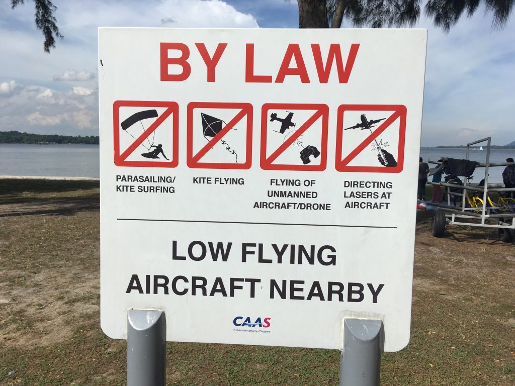 Varovné značky na pláži u letiště Changi